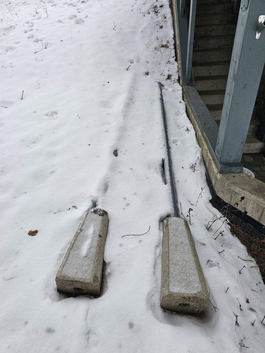 Skiltene ligger på bakken tildekket av snø.